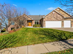 Ranch-style home with a front lawn, concrete driveway, and an attached garage