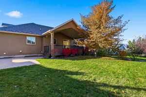 Back of property featuring a wooden deck, stucco siding, a yard, and a patio