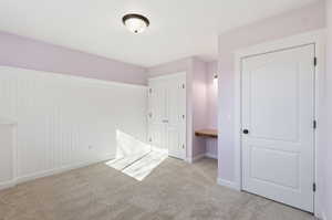 Bedroom 6 with light carpet and a closet