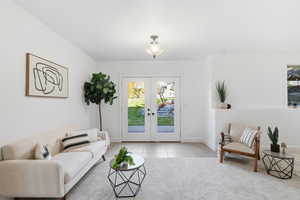 Carpeted living room featuring tile patterned flooring and french doors