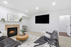 Living area featuring recessed lighting, a fireplace, and light carpet