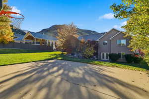 View of side of property with a mountain view, stucco siding, and a patio