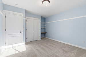 Bedroom 4 featuring light carpet and a closet