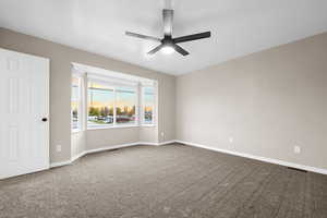 Unfurnished room featuring carpet floors and ceiling fan