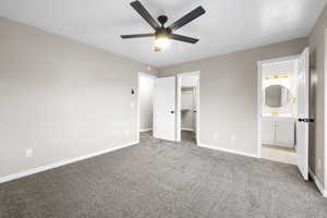 Unfurnished bedroom with light colored carpet, ceiling fan, and a spacious closet
