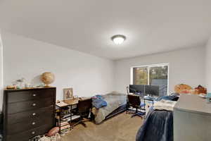 Bedroom with a desk and light colored carpet