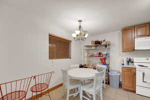 Dining room featuring light tile patterned floors and a chandelier