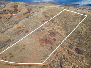 Aerial view of property and surrounding area with property boundaries highlighted and a mountain backdrop