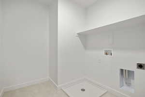 Washroom with washer hookup, electric dryer hookup, and light tile patterned flooring