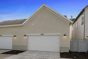 View of property exterior with stucco siding, concrete driveway, and a garage