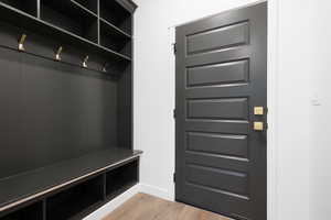 Mudroom with light wood-style flooring and baseboards