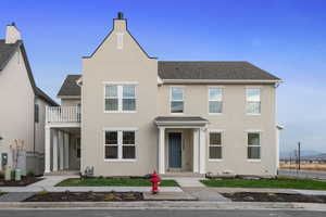 View of front of home with a shingled roof and stucco siding