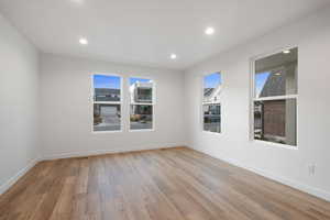 Empty room featuring light wood-style flooring, recessed lighting, and plenty of natural light