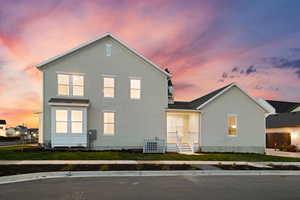 Back of house at dusk featuring stucco siding