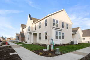 View of home's exterior featuring a residential view, roof with shingles, a chimney, and a lawn