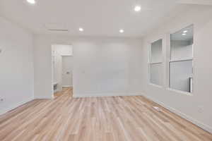 Spare room with recessed lighting, light wood-style floors, and attic access
