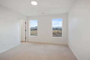 Unfurnished room with light carpet and baseboards