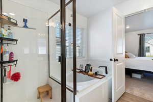 Ensuite bathroom featuring a walk-in shower and garden tub