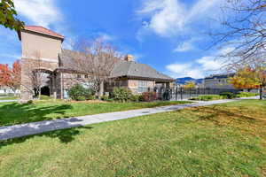 View of front of property featuring stone siding, a chimney, and a standing seam roof