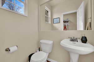 Half bath featuring toilet and baseboards