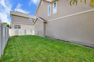 Back of house with stucco siding and a fenced backyard