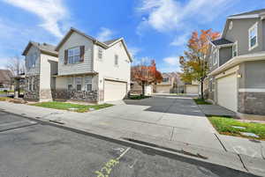 View of side of property with stone siding, a residential view, and driveway