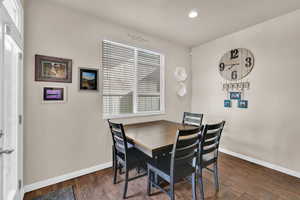 Dining room with dark wood-style floors and recessed lighting