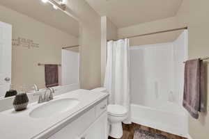 Full bathroom featuring vanity, dark wood-style floors, and shower / tub combo