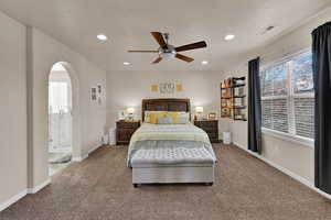 Carpeted bedroom with recessed lighting, a ceiling fan, and arched walkways