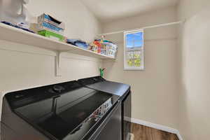 Laundry room featuring dark wood-style floors and washing machine and dryer
