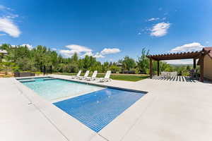 Community pool with a patio and a pergola