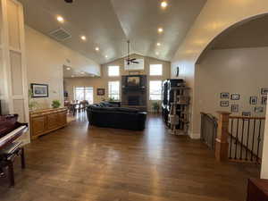 Living room featuring ceiling fan, dark wood finished floors, recessed lighting, high vaulted ceiling, and a fireplace