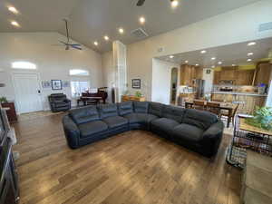 Living area featuring high vaulted ceiling, a ceiling fan, hardwood / wood-style flooring, recessed lighting, and arched walkways