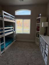 Unfurnished bedroom with light carpet and baseboards