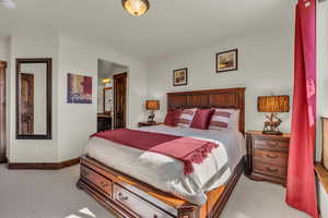 Bedroom with light carpet and connected bathroom