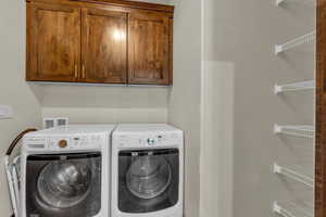 Laundry room with cabinet space and washer and clothes dryer