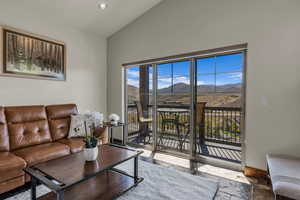 Living area with a mountain view, vaulted ceiling, and recessed lighting