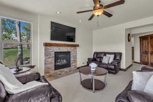 Living room featuring recessed lighting, a fireplace, and a ceiling fan