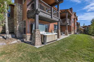 Patio / terrace with a patio area, a hot tub, and a yard