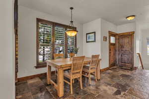 Dining room with baseboards and stone tile flooring