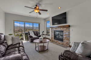 Living room featuring a fireplace, recessed lighting, ceiling fan, and wood finished floors