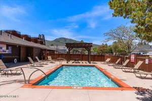 Community pool with a patio, a mountain view, and a pergola