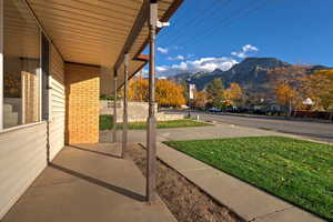 Porch with a mountain view and a yard