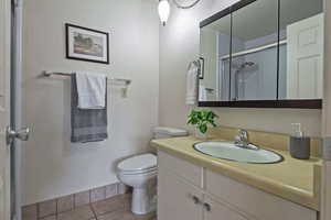 Bathroom with vanity, light tile patterned floors, and an enclosed shower
