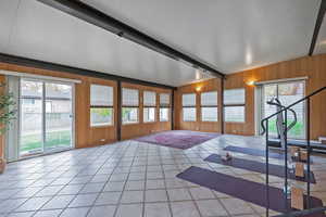 Sunroom featuring wood walls and tile patterned floors