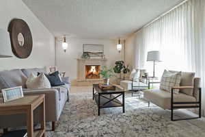 Living room featuring a textured ceiling and a warm lit fireplace