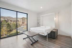 Bedroom featuring recessed lighting, wood finished floors, access to outside, and a mountain view