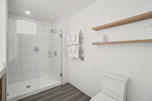 Full bathroom with a shower stall and dark wood finished floors