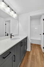 Full bathroom featuring vanity, dark wood-style floors, and shower / tub combination