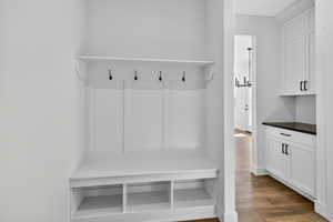 Mudroom with dark wood-style floors and a chandelier